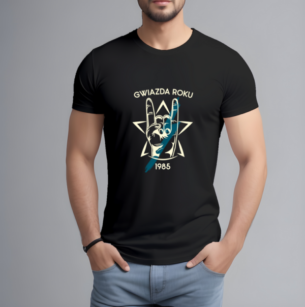Mężczyzna w czarnej koszulce z nadrukiem „GWIAZDA ROKU 1985”. Grafika przedstawia rękę w geście „rock on” (diabelskie rogi) na tle gwiazdy. Koszulka w rockowym stylu, idealna jako prezent urodzinowy z możliwością personalizacji roku.