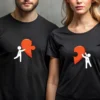 Para w czarnych koszulkach z nadrukiem połówki serca i postaciami, symbolizującymi połączenie dwóch osób. Widoczne personalizowane inicjały.