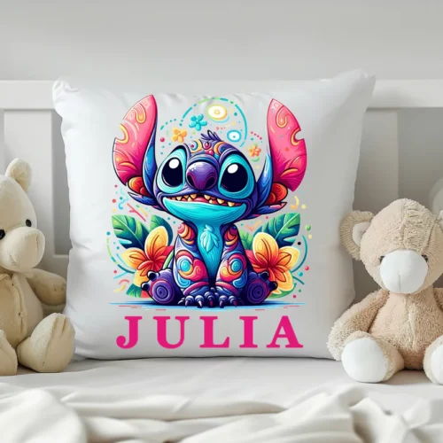 Personalizowana poduszka z kolorowym nadrukiem Stitch, imieniem "Julia" i tropikalnym motywem kwiatowym. Poduszka umieszczona na dziecięcym łóżku w otoczeniu pluszowych misiów.