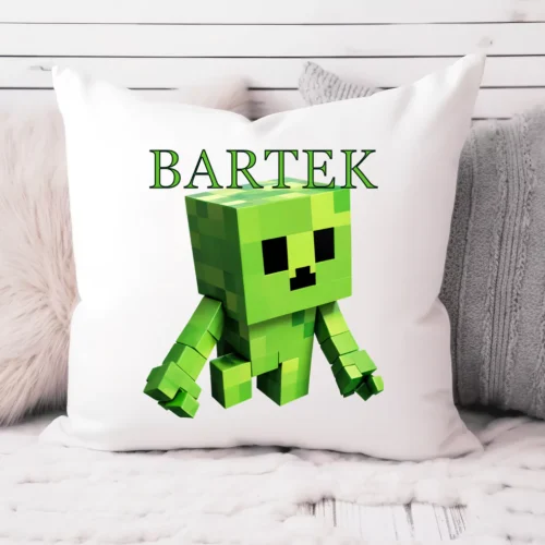 Personalizowana poduszka z zieloną, pikselową postacią w stylu Minecraft i imieniem "Bartek" na białym tle, ułożona na łóżku w otoczeniu szarych i puszystych poduszek.