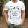 Mężczyzna w personalizowanej koszulce urodzinowej z grafiką przypominającą populerne whisky. Na koszulce widnieje imię Daniel i jego rok urodzenia