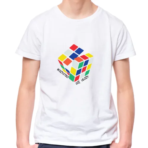 Biała koszulka dziecięca unisex z kolorowym nadrukiem przedstawiającym rozkładającą się Kostkę Rubika i czarnym napisem "WSZYSTKO SIĘ UŁOŻY" wokół niej. Model prezentuje koszulkę na jasnym tle.
