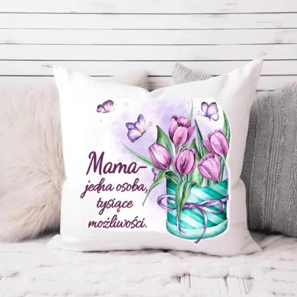 Poduszka dekoracyjna z napisem „Mama – jedna osoba, tysiące możliwości”, ozdobiona fioletowymi tulipanami i motylami, na białym tle.