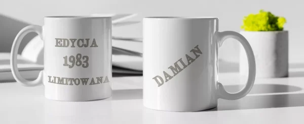 Dwa personalizowane kubki "Edycja Limitowana": jeden z datą 1983, drugi z imieniem Damian, oba ze srebrnymi uchami i napisami.