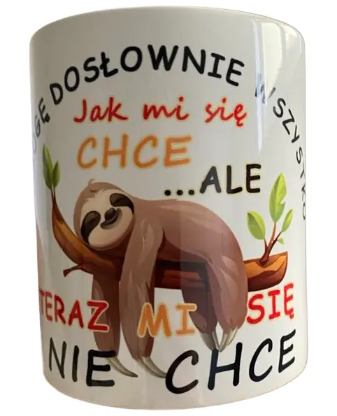 Biały ceramiczny kubek z nadrukiem śpiącego leniwca i napisem "JA MOGĘ DOSŁOWNIE WSZYSTKO Jak mi się CHCE ...ALE TERAZ MI SIĘ NIE CHCE" na białym tle.