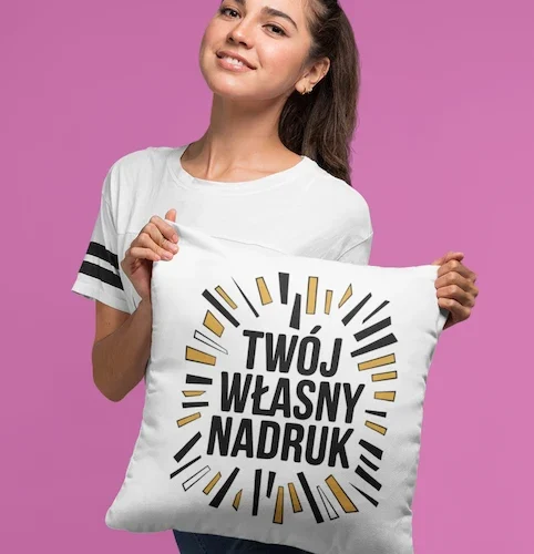 Uśmiechnięta kobieta trzymająca białą poduszkę z napisem "Twój Własny Nadruk", prezentująca personalizowany produkt.
