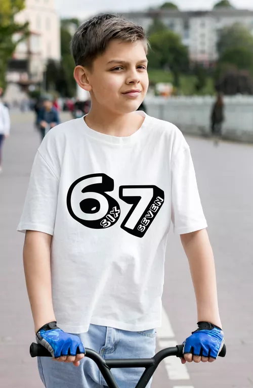 Chłopiec w białej bawełnianej koszulce z czarnym nadrukiem '67 SIX SEVEN', siedzący na hulajnodze, symbolizujący swobodę i aktywność.