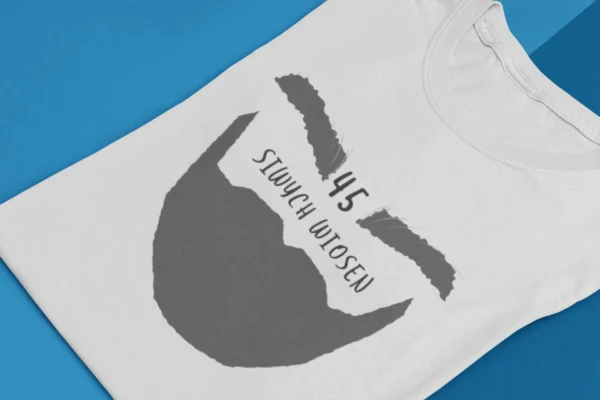 Złożona biała koszulka z grafiką brody i napisem 45 siwych wiosen