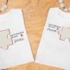Dwie białe koszulki z nadrukiem puzzla i imionami Gosia oraz Paweł na drewnianym tle