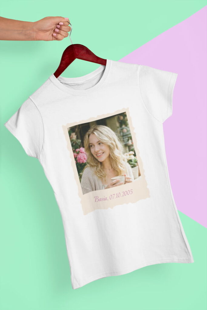 Biała koszulka damska z nadrukiem zdjęcia i napisem wisząca na drewnianym wieszaku