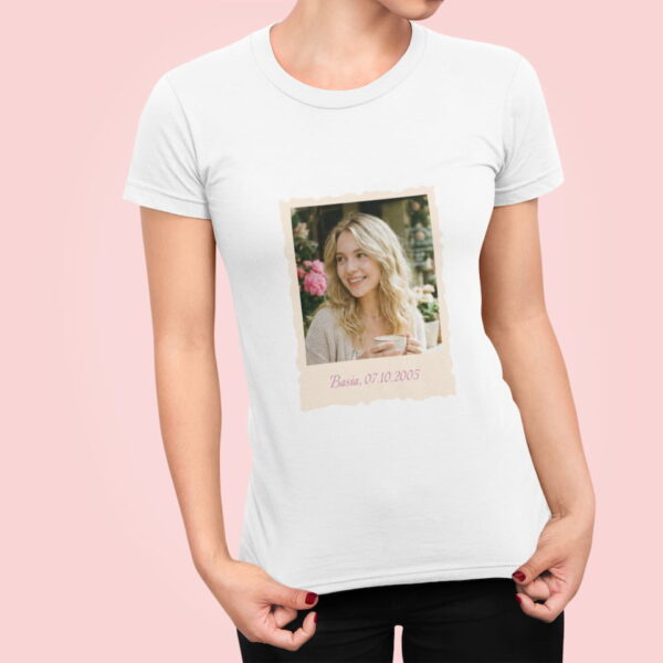 Kobieta ubrana w białą koszulkę z nadrukiem zdjęcia w ramce typu polaroid i własnym podpisem