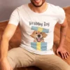 Mężczyzna siedzący w białej koszulce z nadrukiem labradora i napisem Birthday Boy