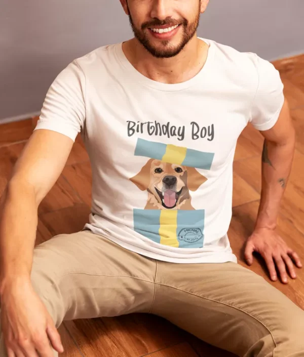 Mężczyzna siedzący w białej koszulce z nadrukiem labradora i napisem Birthday Boy