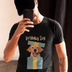 Mężczyzna robiący selfie w czarnej koszulce z labradorem wyskakującym z pudełka