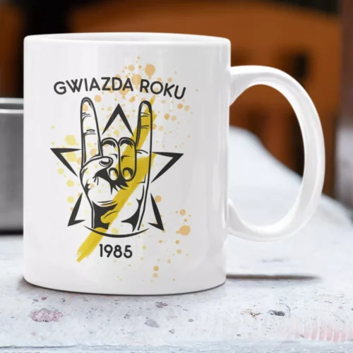Biały ceramiczny kubek z grafiką dłoni w geście rockowym, żółtą gwiazdą i personalizowaną datą 1985