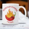 Biały ceramiczny kubek z ilustracją płonącej papryczki chili w okularach przeciwsłonecznych i personalizowanym napisem Rozgrzewam Atmosferę Michał.