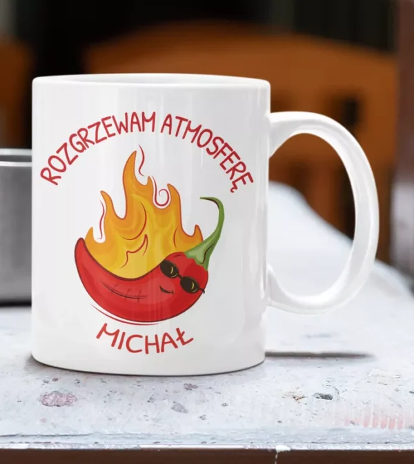 Biały ceramiczny kubek z ilustracją płonącej papryczki chili w okularach przeciwsłonecznych i personalizowanym napisem Rozgrzewam Atmosferę Michał.