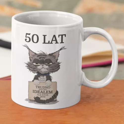 Biały ceramiczny kubek z grafiką zrzędliwego kota i personalizowanym napisem 50 lat Trudno jest być ideałem ale ktoś musi.